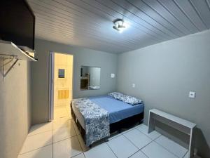 a bedroom with a bed in a room with a ceiling at Pousada da Cia in Blumenau