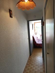 un couloir avec un lustre suspendu au plafond dans l'établissement Studio à deux pas de la mer, au Grau-du-Roi