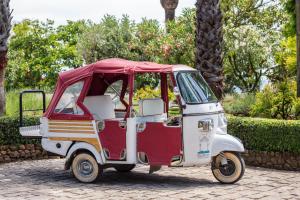 a red and white golf cart parked in a park at Villa Irlanda Grand Hotel in Gaeta