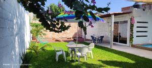 a patio with a table and chairs and an umbrella at Casa Guacamayas in Tlatenchu