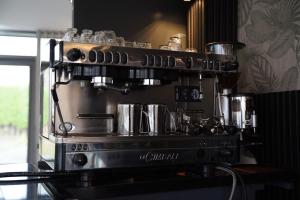 a coffeemachine with pots and pans on top of it at MA Hotel Amsterdam Schiphol Airport in Hoofddorp