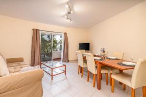 a living room with a dining room table and a couch at Cool Motion Rocha Beach T2 in Portimão