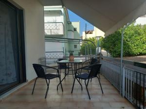 a patio with a table and chairs on a balcony at Kyparissia Bliss in Kyparissia