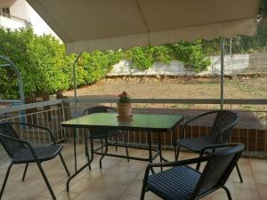 a table and chairs on a patio with an umbrella at Kyparissia Bliss in Kyparissia