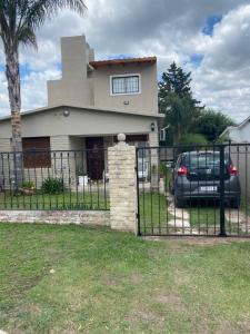 ein Haus mit einem Tor und einem Auto vor dem Haus in der Unterkunft TANTI casa con pileta in Cordoba