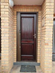 a wooden door on a brick building with a brick wall at Place of Grace in Cape Town