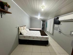 a small room with a bed and a tv at Pousada da Cia in Blumenau +19 photos