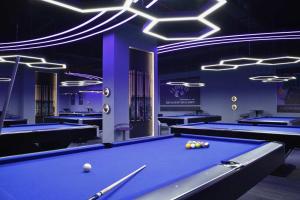 una sala de billar con iluminación púrpura y mesa de billar en Home sweet home san siro, en Milán