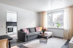a living room with a couch and a window at Cozy 1BR Apartment next to the Beach with Free Parking in Lahti
