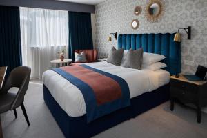 a bedroom with a large bed with a laptop on it at Queens Hotel & Spa Bournemouth in Bournemouth