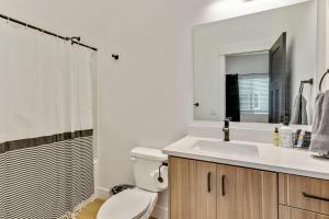 a bathroom with a toilet and a sink and a mirror at 3 Mins to DT Lux Townhome 2 Car Garage King Bed in Salt Lake City +24 photos