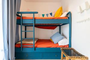Dos literas en una habitación pequeña con un banco. en Salou Luxury Stay Beach Pool WiFi AC, en Salou 39 fotos más