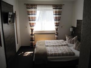 a bedroom with a bed and a window at Hotel Nußknacker in Fulda