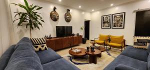a living room with a blue couch and a tv at Private cosy home close to city center with views in Kigali