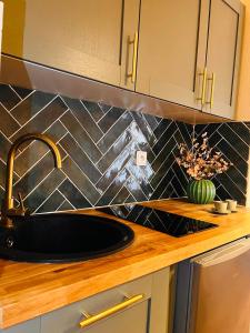 a kitchen sink with a faucet and a counter at La Suite Marrakech, Balneo et Parking in Obernai