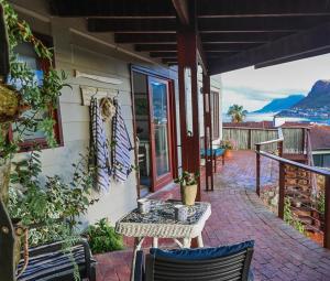 a porch of a house with a table and chairs at 64 on Clovelly in Clovelly