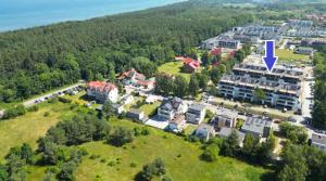 an aerial view of a building on a hill with a purple arrow at POSESJA APARTAMENTY & SPA - Posesja Plażowa 4a I in Grzybowo