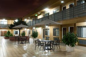 an outdoor patio with tables and chairs and umbrellas at Gardena Terrace Inn in Gardena