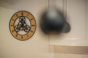 a clock hanging on a wall with a blacklierlierlier clock at Alvera Apartament in Alba Iulia +28 photos