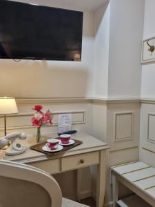 ein Zimmer mit einem Schreibtisch, auf dem eine Blumenvase steht in der Unterkunft Hotel Charly in Mailand