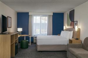 a hotel room with a bed and a couch at Spark by Hilton Denver International Airport in Denver