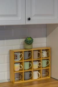 a cabinet filled with cups and plates and a potted plant at Alvera Apartament in Alba Iulia