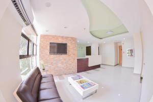 a living room with a couch and a tv on a brick wall at Emerald Suites CDO in Cagayan de Oro