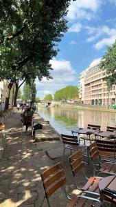 a group of chairs and tables next to a river at Full house Canal Saint-Martin in Paris