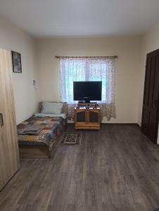 sala de estar con TV de pantalla plana y cama en Конна база Ескус Хорсес, en Gigen 39 fotos más