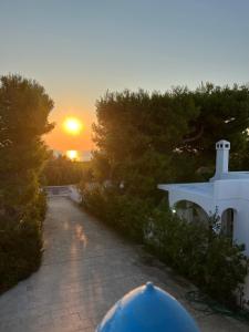a person walking down a path with the sunset in the background at Acqua di Mare in Torre Specchia Ruggeri
