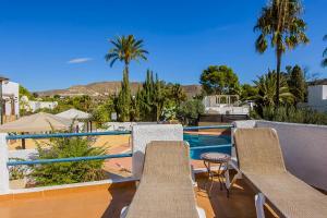 a patio with chairs and a swimming pool at Family Agua Amarga in Agua Amarga