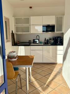 una cucina con mobili bianchi e un tavolo di legno di muchhome LUXURY APARTMENTS - MuchLoft - Vintage Loft in Bad Tölz mit Freizeitlounge a Bad Tölz