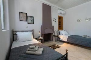 a bedroom with two beds and a fireplace at Erika's home in Leonidio +28 photos