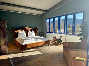 una camera da letto con un letto, un divano e finestre di muchhome LUXURY APARTMENTS - MuchLoft - Vintage Loft in Bad Tölz mit Freizeitlounge a Bad Tölz Altre 31 foto