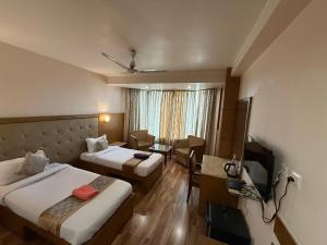 グワーハーティーにあるMW Hotelのベッド2台と机があるホテルの部屋 +11枚の写真