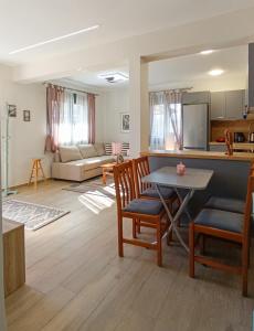 a kitchen and living room with a table and chairs at Cozy Bungalow in Tríkala
