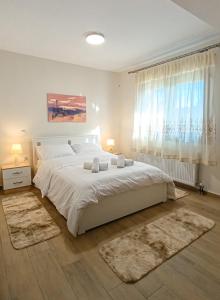 a bedroom with a large bed with white sheets and rugs at Cozy Bungalow in Tríkala +15 photos