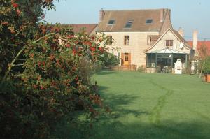 a large brick house with a yard with a tree at La Parenthèse in La Couture