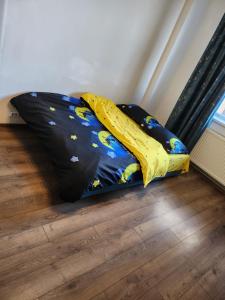 a bed with a yellow blanket on the floor at Exceptional Apartment - Gara de Nord in Bucharest