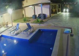 two chairs and a swimming pool in a building at Dunas residence casa 04 in Santo Amaro