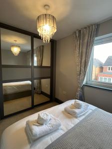 a bedroom with a large mirror and towels on a bed at Luxury Durham Home in DH1, Free Parking, No Fees in Durham