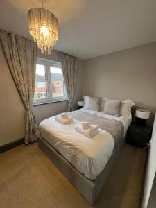 a bedroom with a large bed with a chandelier at Luxury Durham Home in DH1, Free Parking, No Fees in Durham