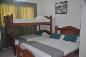 a bedroom with two bunk beds with blue pillows at Hotel San Rafael in Sincelejo