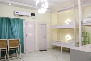 una habitación con dos literas y una mesa en The Sweven Rishikesh, en Rishīkesh