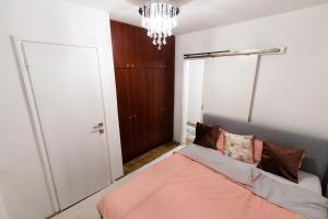 een slaapkamer met een bed en een kroonluchter bij Tanja in Banja Luka