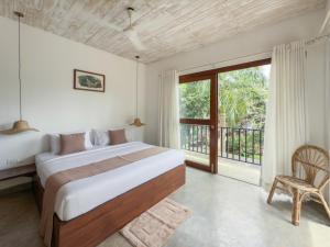 a bedroom with a bed and a large window at La Luna Hiriketiya in Dickwella +6 photos