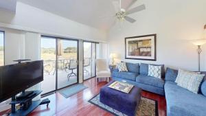 a living room with a blue couch and a flat screen tv at Getaway to the Beach 2 Bdrm Villa with Amenities in Pawleys Island