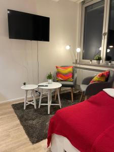 Una sala de estar con televisión, mesa y sillas. en Modernes City-Apartment Nähe Uniklinikum und Zentrum, en Augsburg