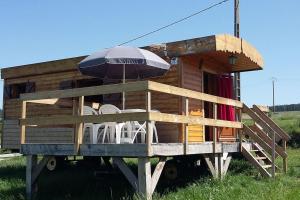 拉图多韦尔尼Belle roulotte de style chalet au coeur du Sancy的一辆卡车后方的房屋,带雨伞