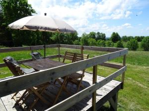 拉图多韦尔尼Belle roulotte de style chalet au coeur du Sancy的甲板上配有一张带遮阳伞和椅子的木桌 更多8张照片